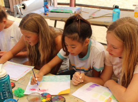 girls learning to paint in class