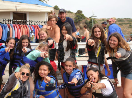 counselors and campers posing for a photo with lifejackets on by the dock