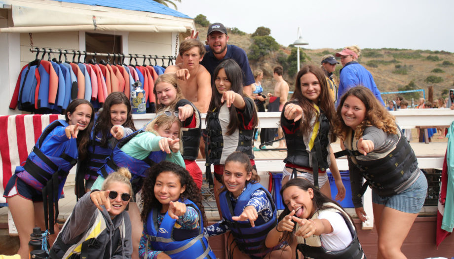 counselors and campers posing for a photo with lifejackets on by the dock