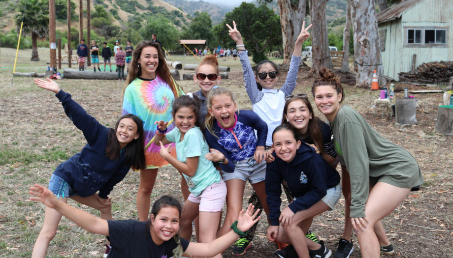 girls posing for a group photo by the climbing wall