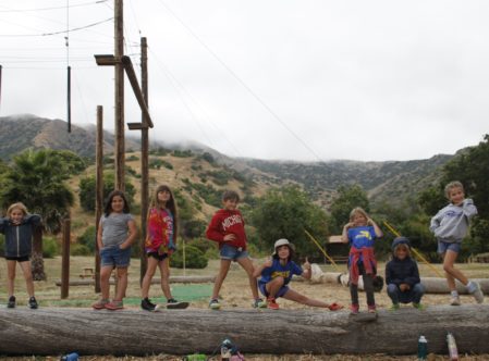 campers posing on a big log